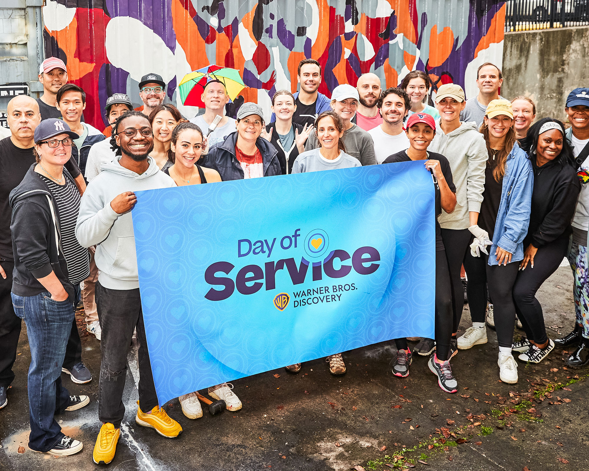 Photo of a group of WBD employees posing with a "Day of Service" banner